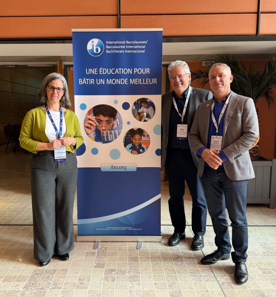 ELSA Board officers David Johnson and Antoine Delaitre with another attendee beside an IB banner at IB Associations Day in Lyon